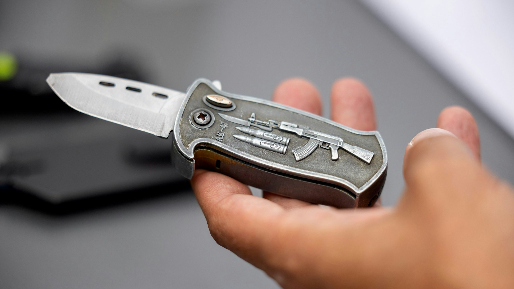 Ein Polizeibeamter hält ein sichergestelltes, verbotenes Springmesser in der Hand.