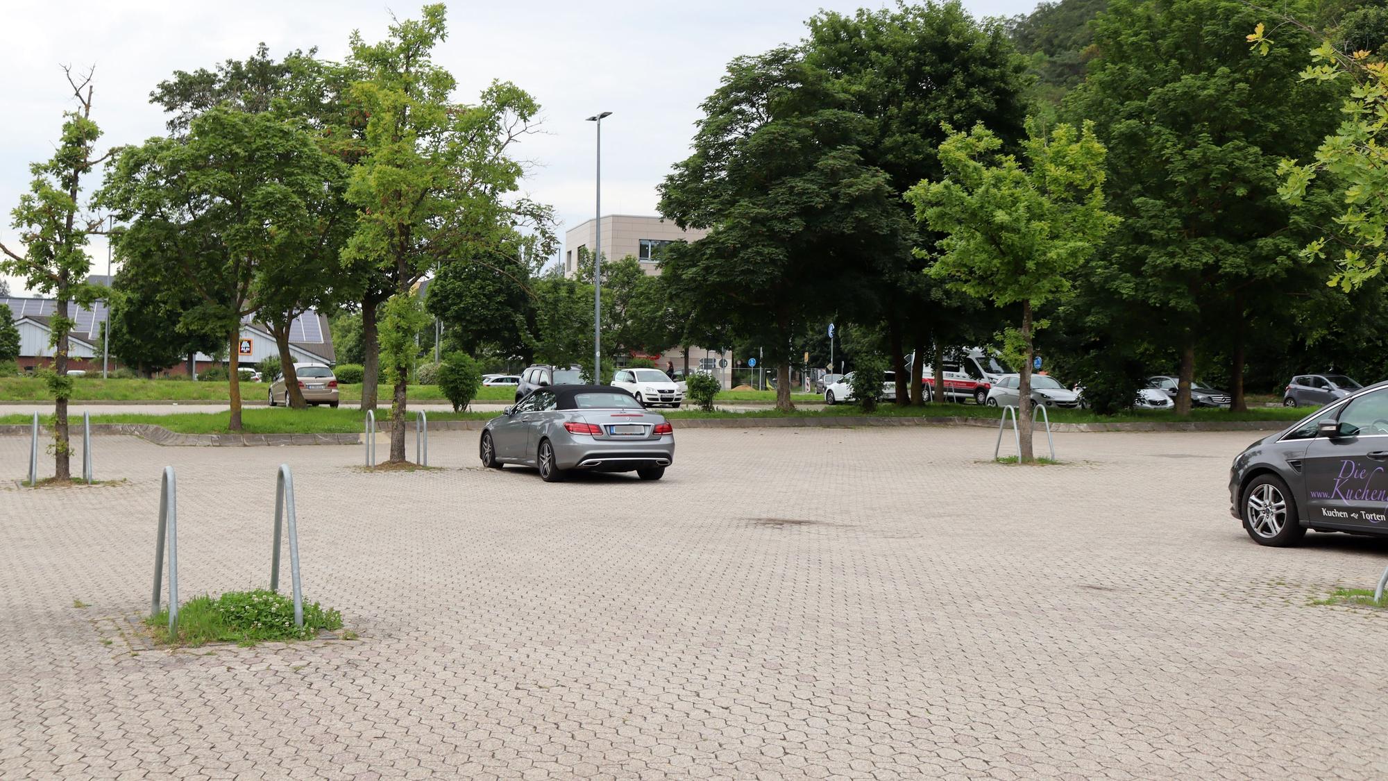 Das Bild zeigt einen fast leeren Parkplatz. Im Hintergrund ist klein ein Outlet-Gebäude zu erkennen.