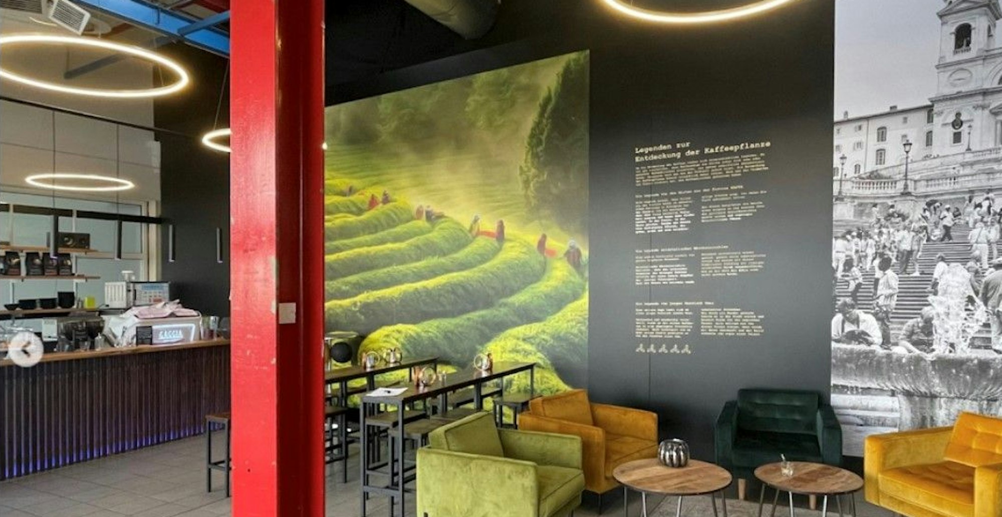 Sieben Berge Rheinland Café mit Theke und Sitzgelegenheiten. Im Vordergrund eine rote Säule.