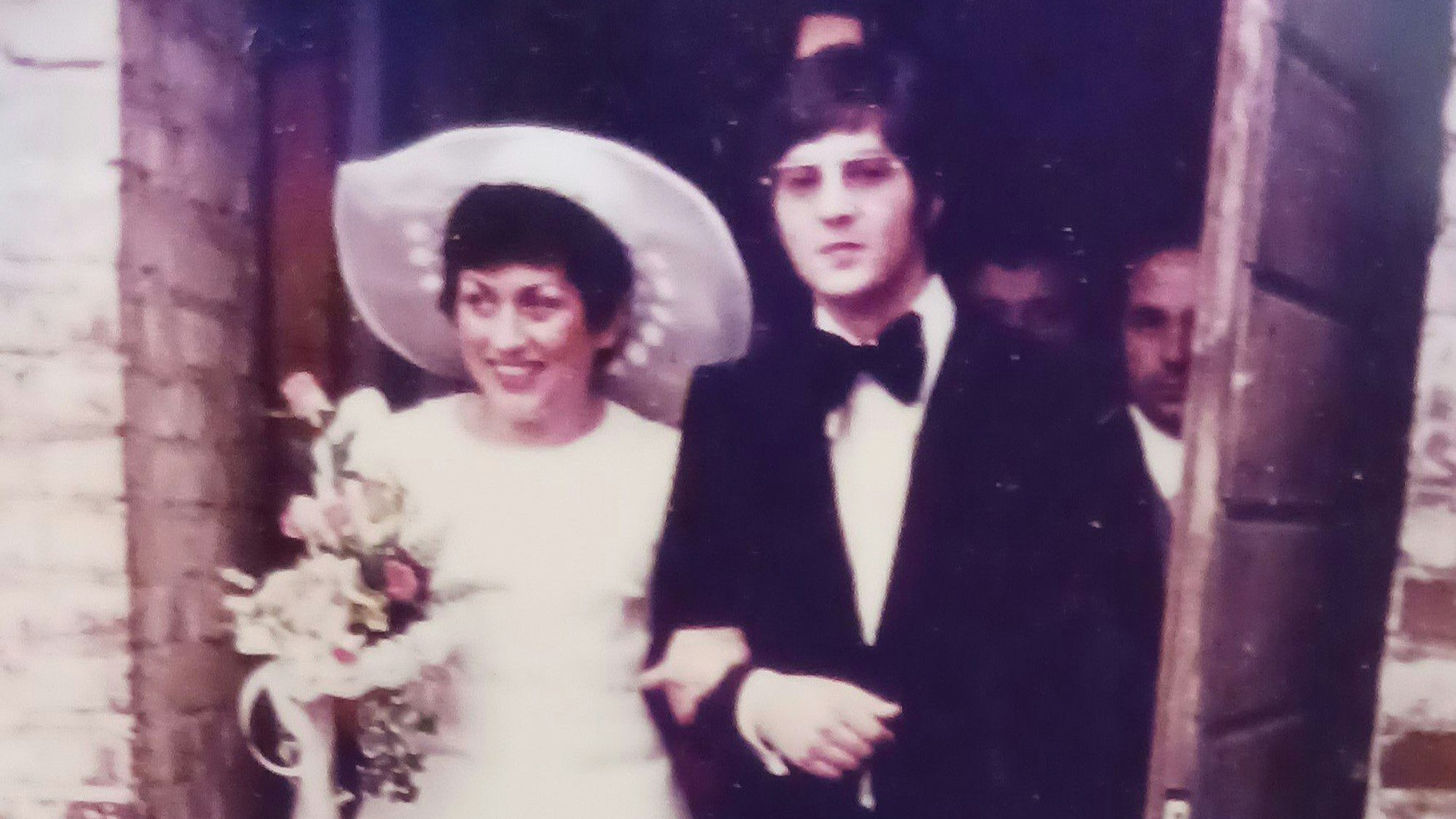 Das frisch getraute Paar - sie in Weiß, er im Anzug mit Fliege - verlässt die Elsdorfer Pfarrkiche.