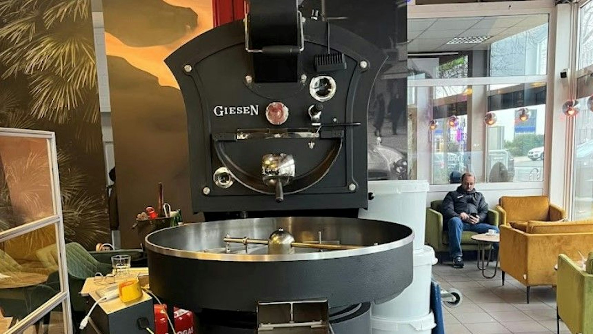 Ein Trommelröster. Im Hintergrund Sitzgelegenheiten und ein Gast.