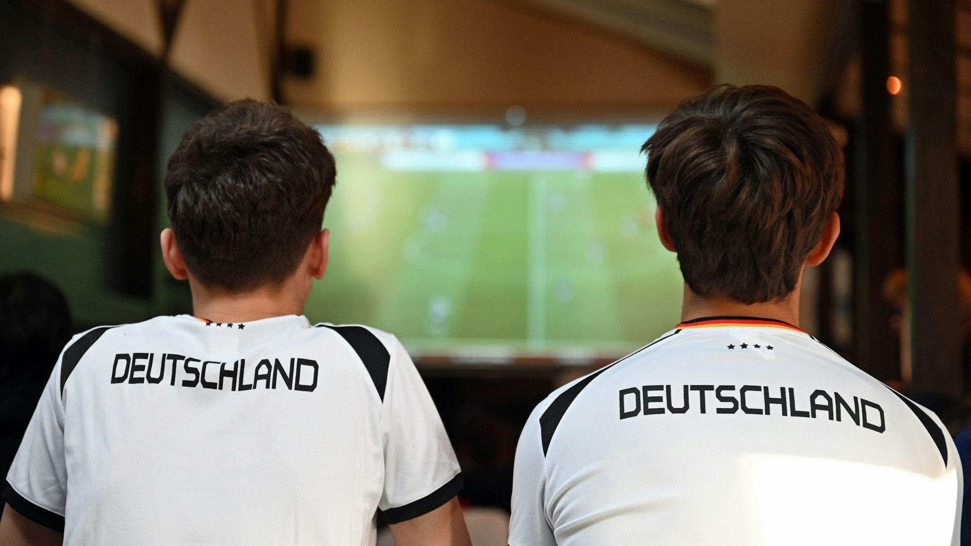 ARCHIV - 10.11.2022, Berlin: Zwei junge Männer sehen sich ein Fußballspiel in einer Berliner Kneipe an. In Hessen ist das EM-Fieber noch überschaubar. (zu dpa: «Privat statt Public Viewing? Kaum EM-Fieber in Hessen spürbar») Foto: Lena Lachnit/dpa +++ dpa-Bildfunk +++