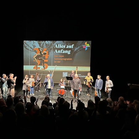 Menschen stehen auf einer Bühne.