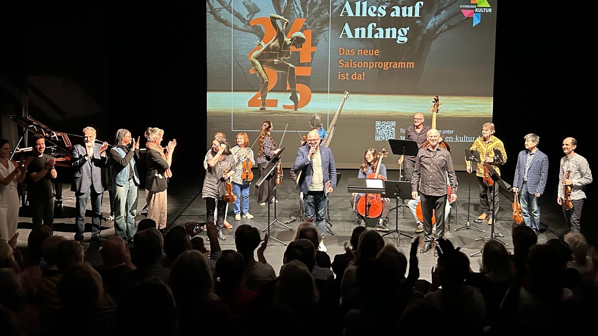Menschen stehen auf einer Bühne.