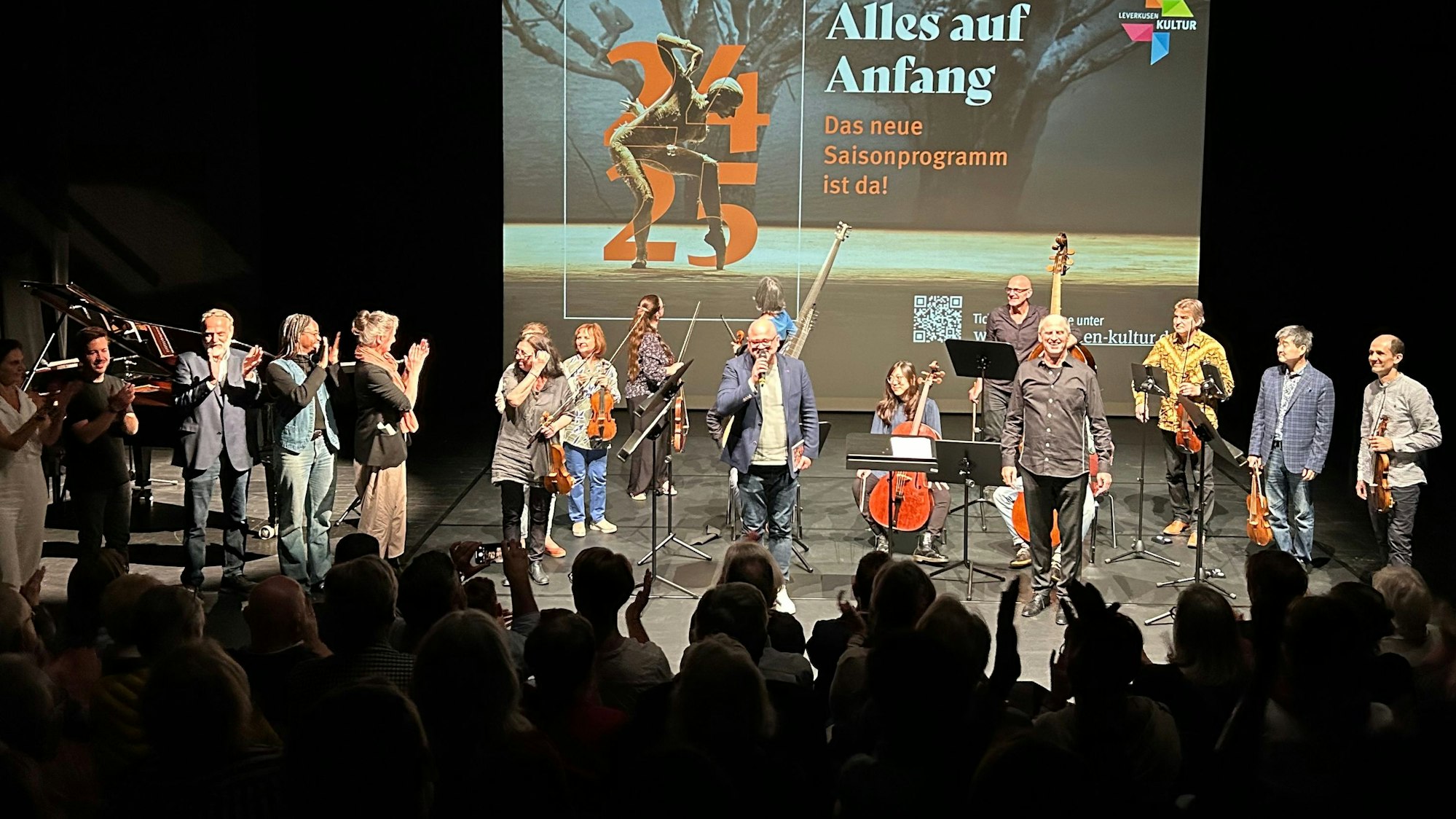 Menschen stehen auf einer Bühne.