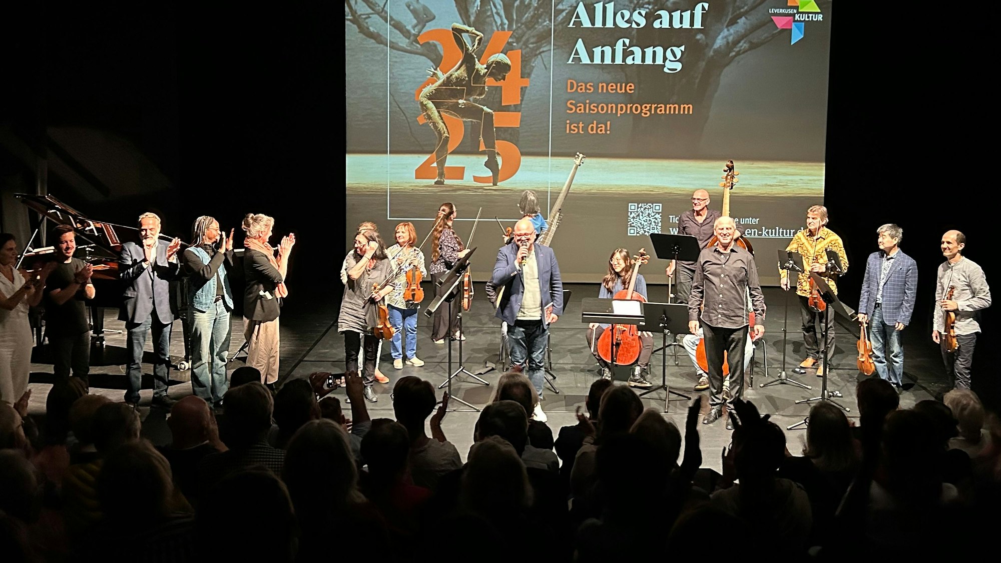 Menschen stehen auf einer Bühne.