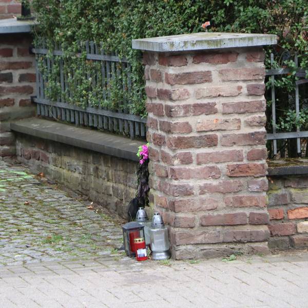 Am Fuß einer Mauer stehen Kerzen, sie erinnern an die Unfallopfer.