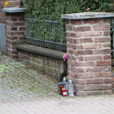 Am Fuß einer Mauer stehen Kerzen, sie erinnern an die Unfallopfer.