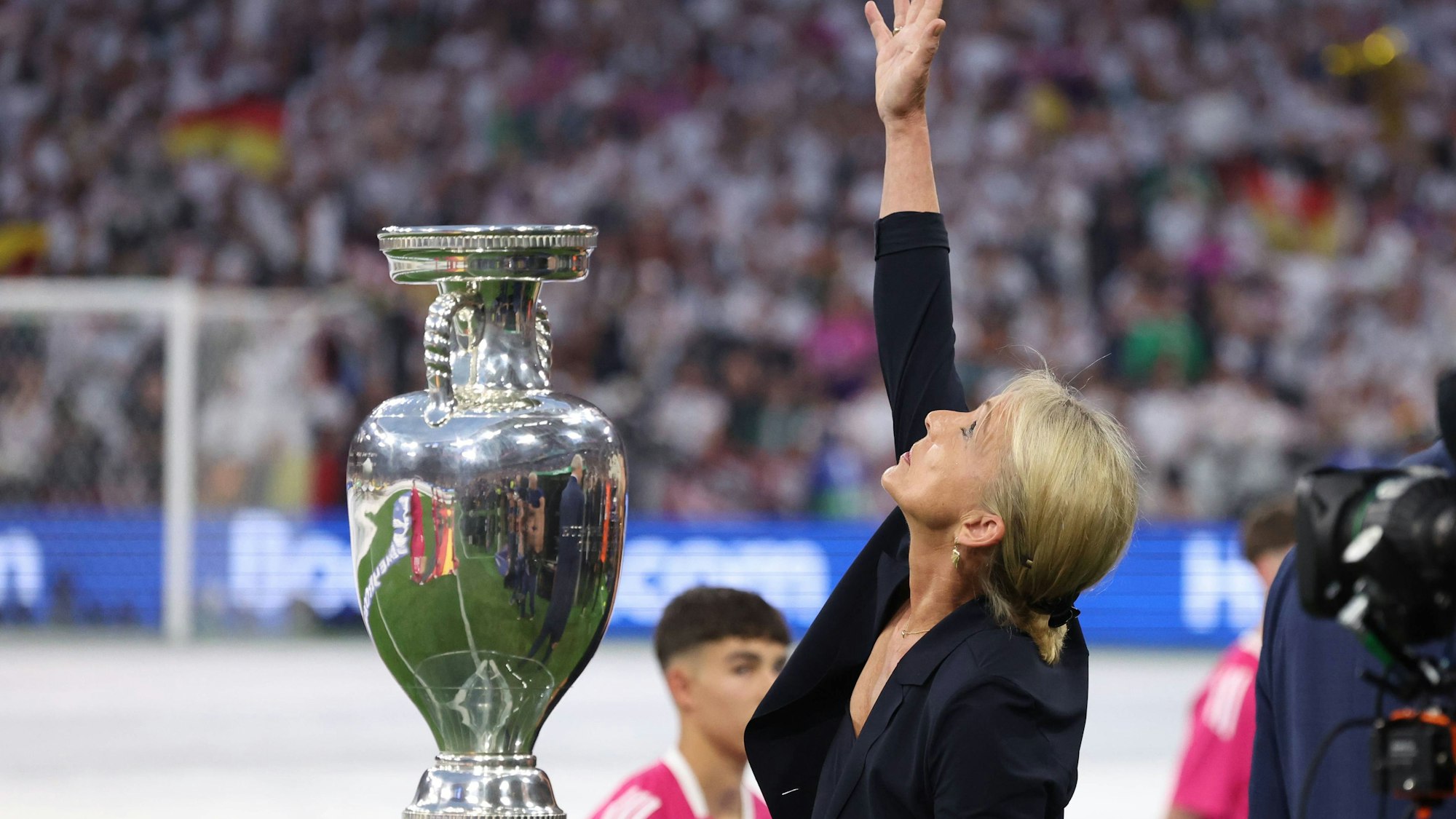 Heidi Beckenbauer greift zum Ende der Eröffnungsfeier der EM 2024 Richtung Himmel zu ihrem verstorbenen Ehemann Franz Beckenbauer.