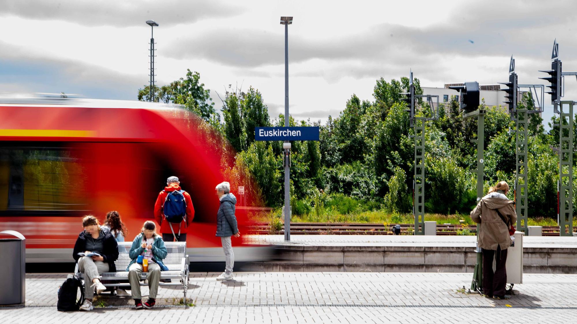 Modellbau des Bahnhofs mit wartenden Menschen und einem Zug vor dem Ortsschild Euskirchen.