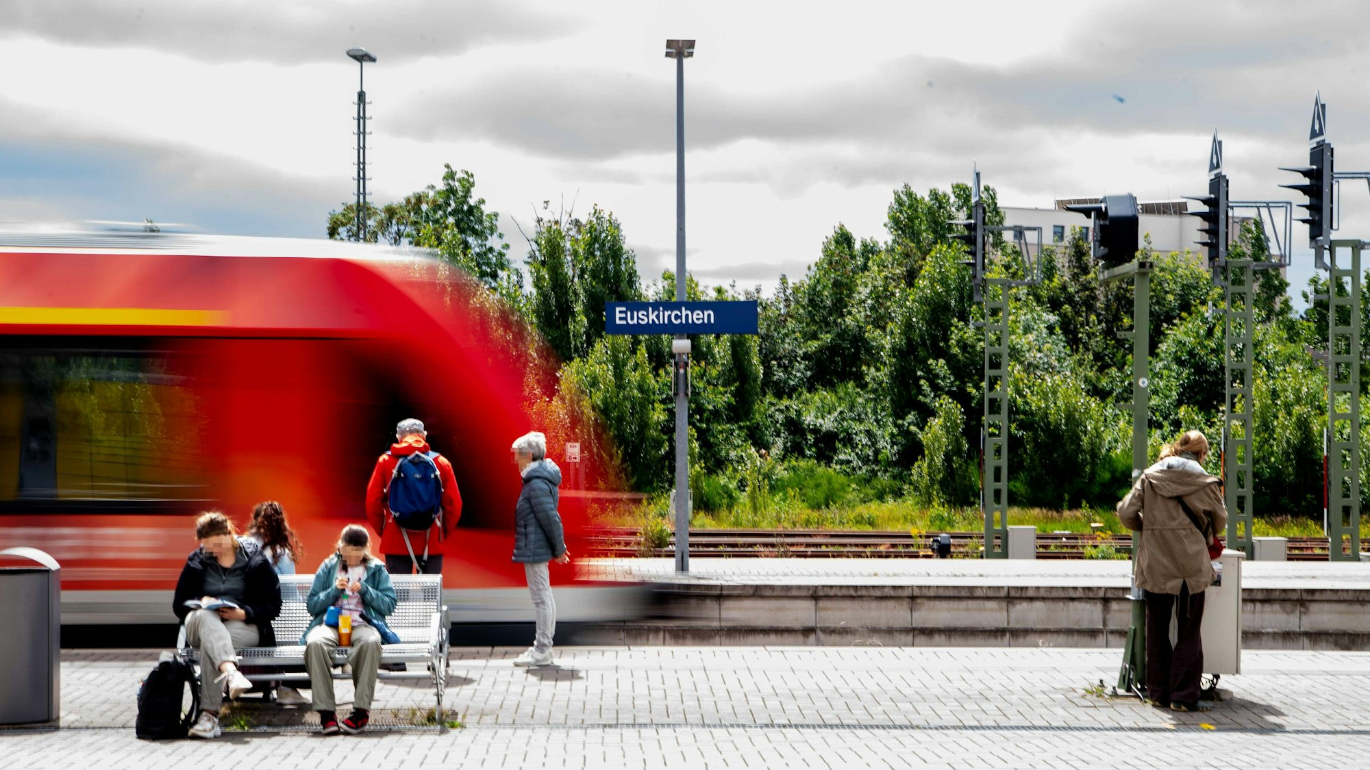 Modellbau des Bahnhofs mit wartenden Menschen und einem Zug vor dem Ortsschild Euskirchen.