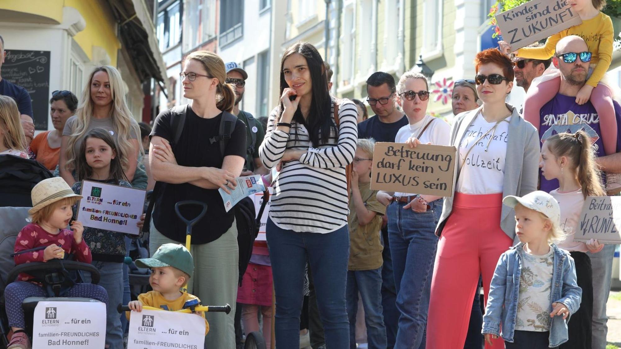 Eltern und Kinder demonstrieren mit Schildern und Plakaten.