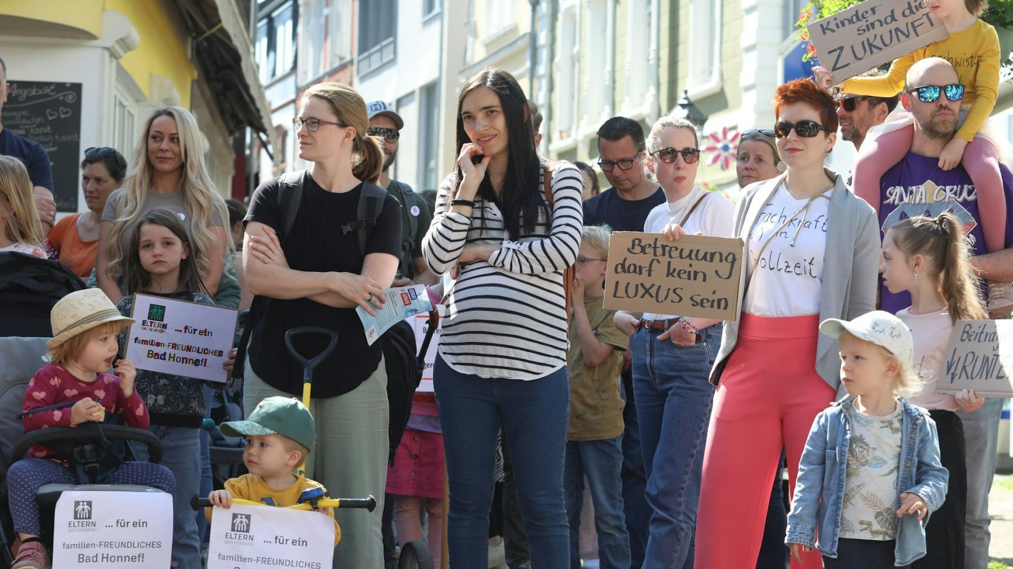 Eltern und Kinder demonstrieren mit Schildern und Plakaten.