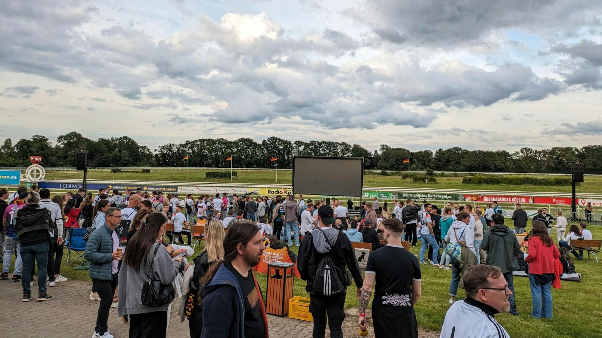 Fußball-Fans sammeln sich vor der Ersatzleinwand auf der Galopprennbahn in Weidenpeach zum Public Viewing.