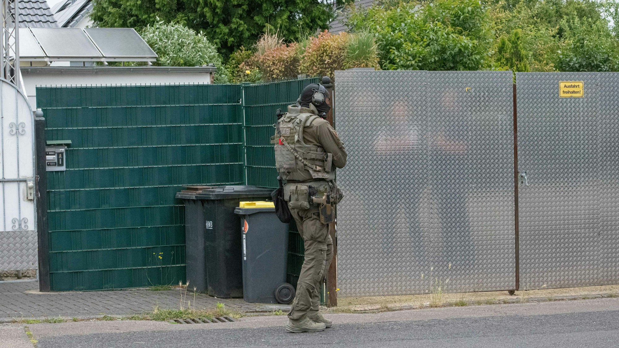 Ein Beamter des SEK der Kölner Polizei vor einem Haus im Stadtteil Vogelsang. Das SEK stürmte eine Wohnung in einem Mehrfamilienhaus, in dem sich eine bewaffnete Frau verschanzt hatte.