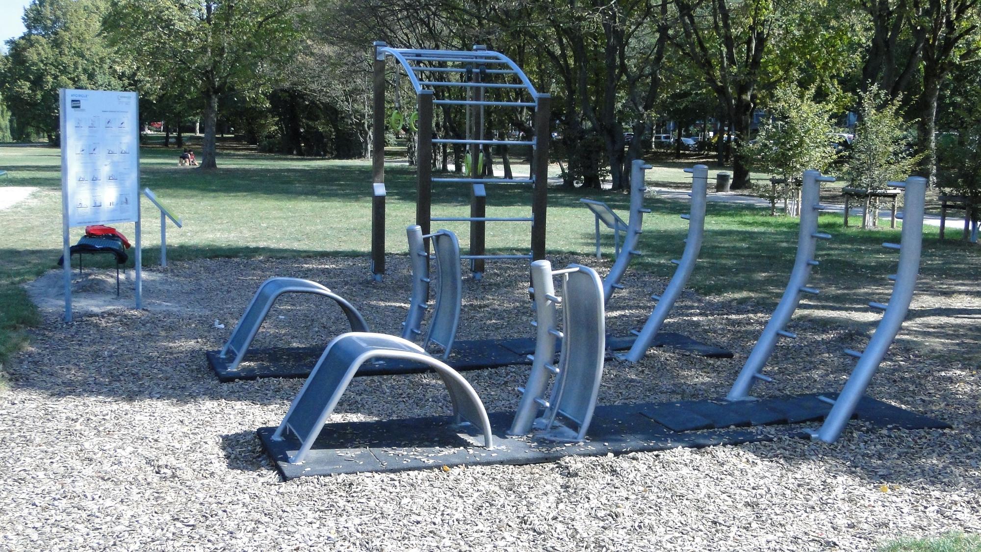 Auf einer begrenzten Fläche stehen Outdoor-Fitnessgeräte im Nippeser Lohsepark.