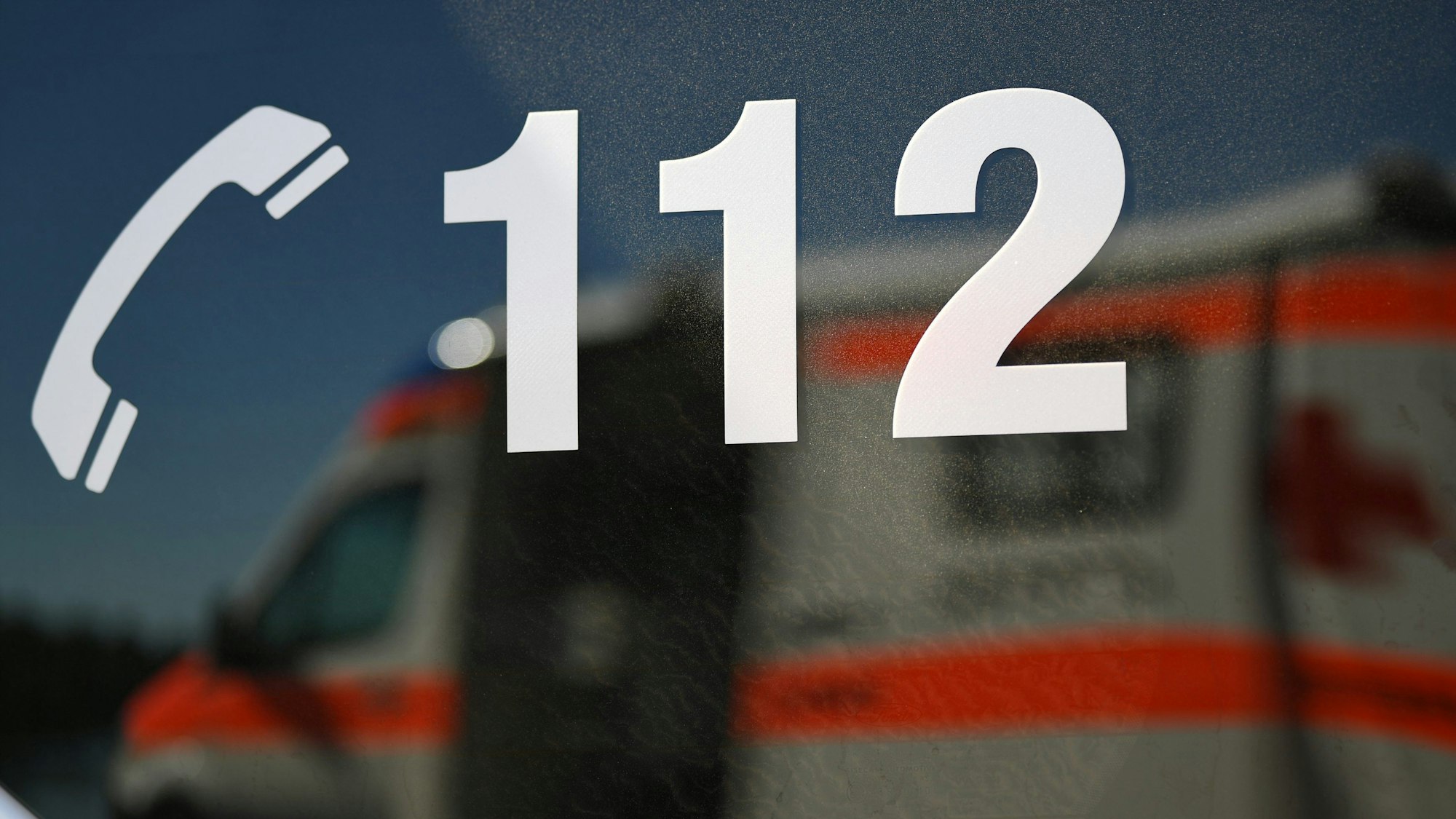 ARCHIV - 01.06.2019, Baden-Württemberg, Freiburg: Ein Rettungswagen spiegelt sich während einer Übung in einem Fenster eines anderen Rettungswagen mit der Aufschrift "112". (zu dpa: «Mehr Ersthelfer bekommen Hilfe bei der Reanimation») Foto: Patrick Seeger/dpa +++ dpa-Bildfunk +++
