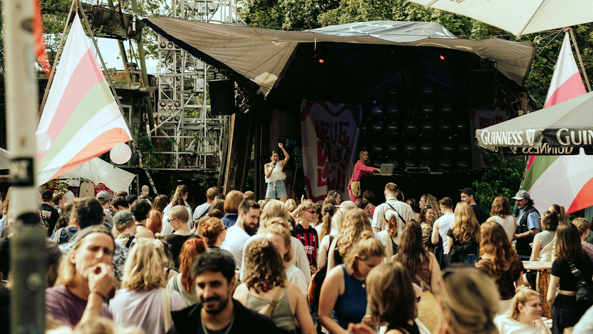 Menschen stehen vor einer Open-Air-Bühne.
