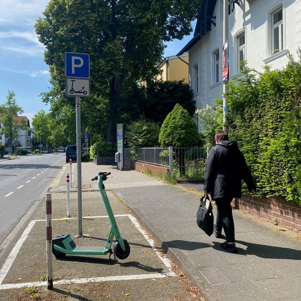 Zu sehen ist eine mit Schild und Markierung gekennzeichnete Abstellzone an einer Straße.
