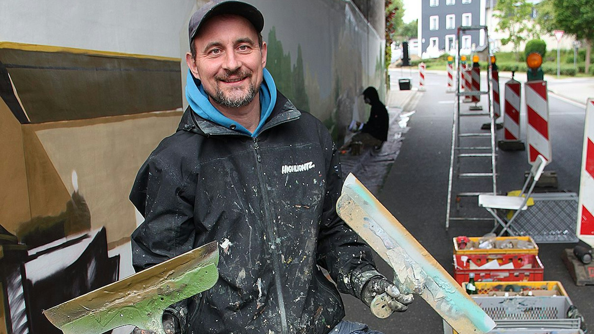 Stefan Vogt-Thomas hält zwei Spachtel hoch.