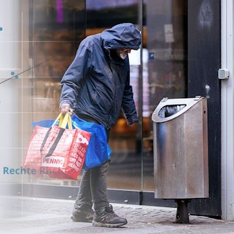 Die Grafik einer linearen Regression zwischen Einkommen und Lebenserwartung geht in ein Bild über, das einen obdachlosen Mann neben einem Mülleimer auf der Kölner Schildergasse zeigt.