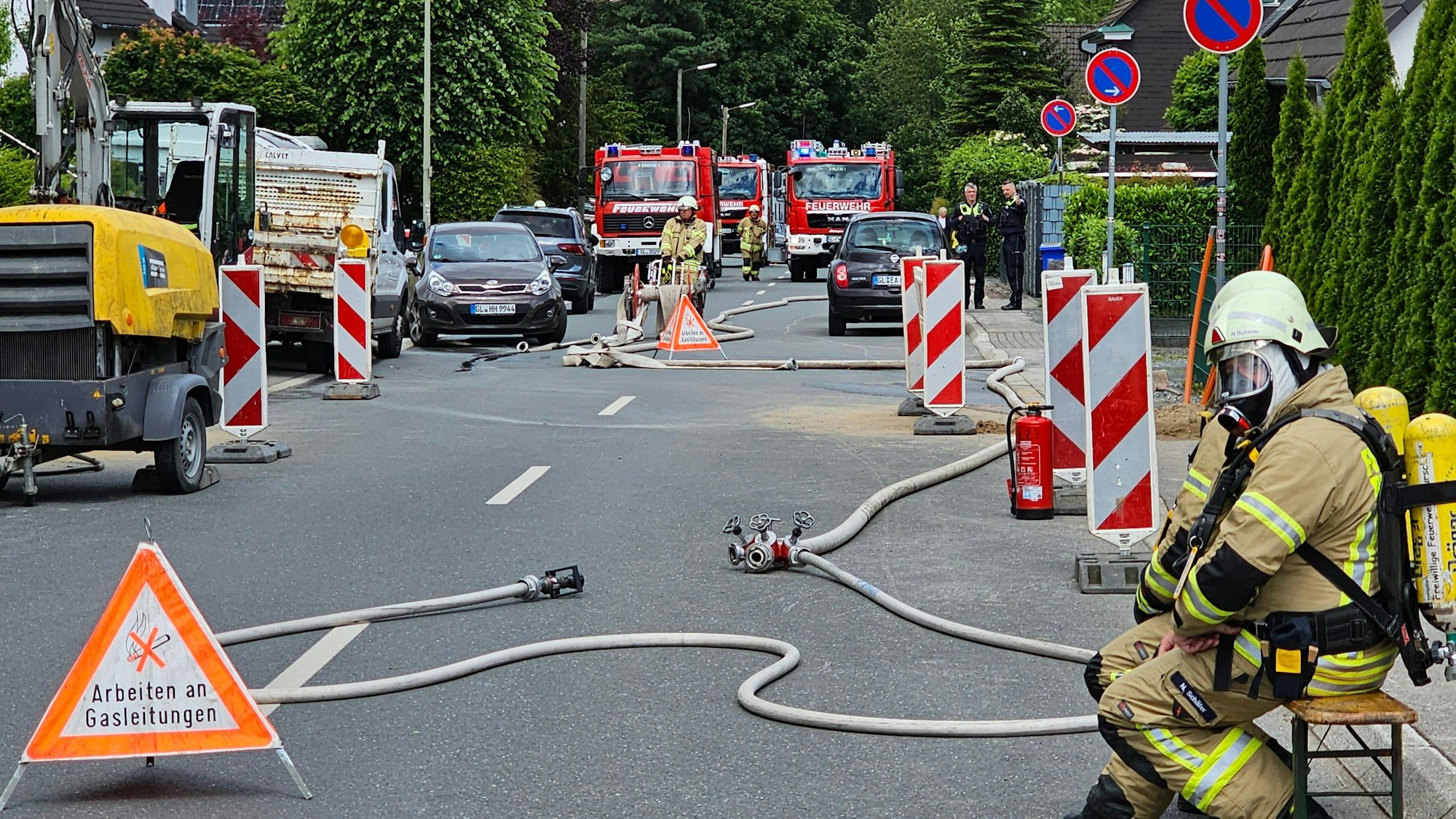 Feuerwehrleute in Schutzkleidung sitzen am 15. Juni auf der Durchgangsstraße in Nagelsbaum.