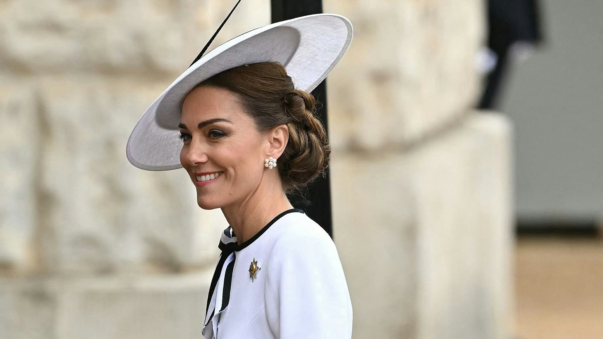 Prinzessin Kate mit weißem Hut und Kleid. Sie lächelt.