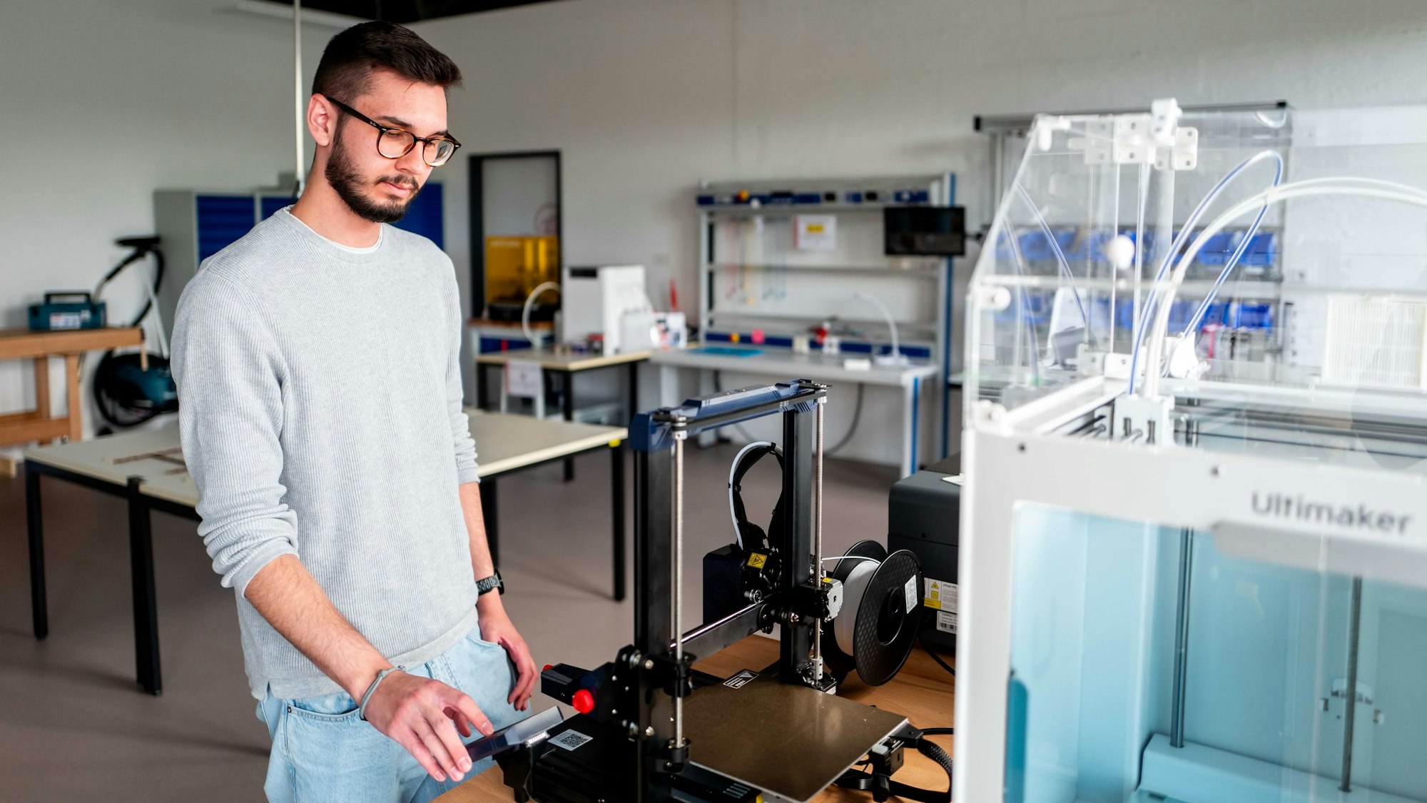 Ein Mann bedient den 3D-Drucker.