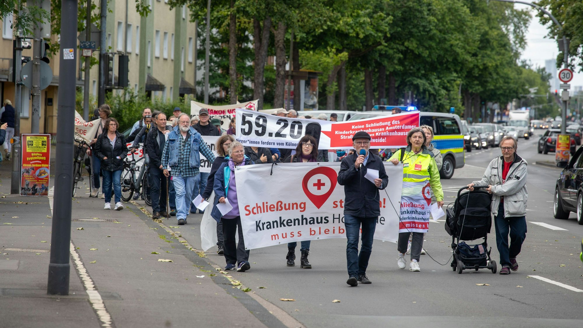 Menschen demonstrieren für den Erhalt des Krankenhauses Holweide und für die Kinderklinik an der Amsterdamer Straße. Der Demonstrationszug am 15. Juni führte über die Bergisch Gladbacher Straße bis zum Krankenhaus Holweide.