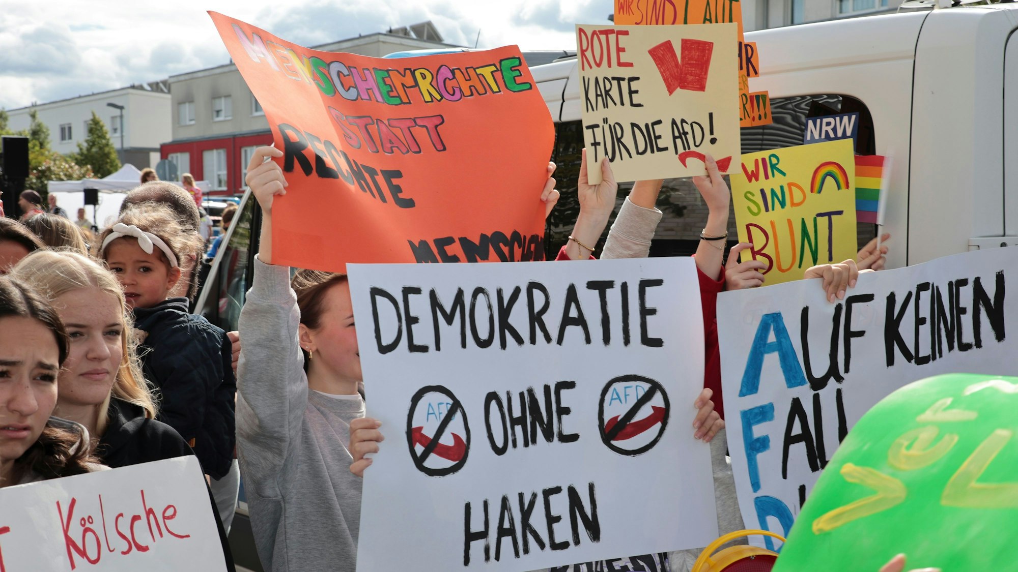 Menschen mit Plakaten und Schriftzügen wie „Demokratie ohne Haken“, oder „Rote Karte für die AfD“ demonstrieren in Köln.