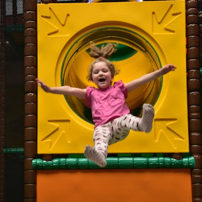 Ein kleines Mädchen rutsch auf der Big Airbag-Rutsche im neuen Troisdorfer Indoorspielplatz Monkey Town.