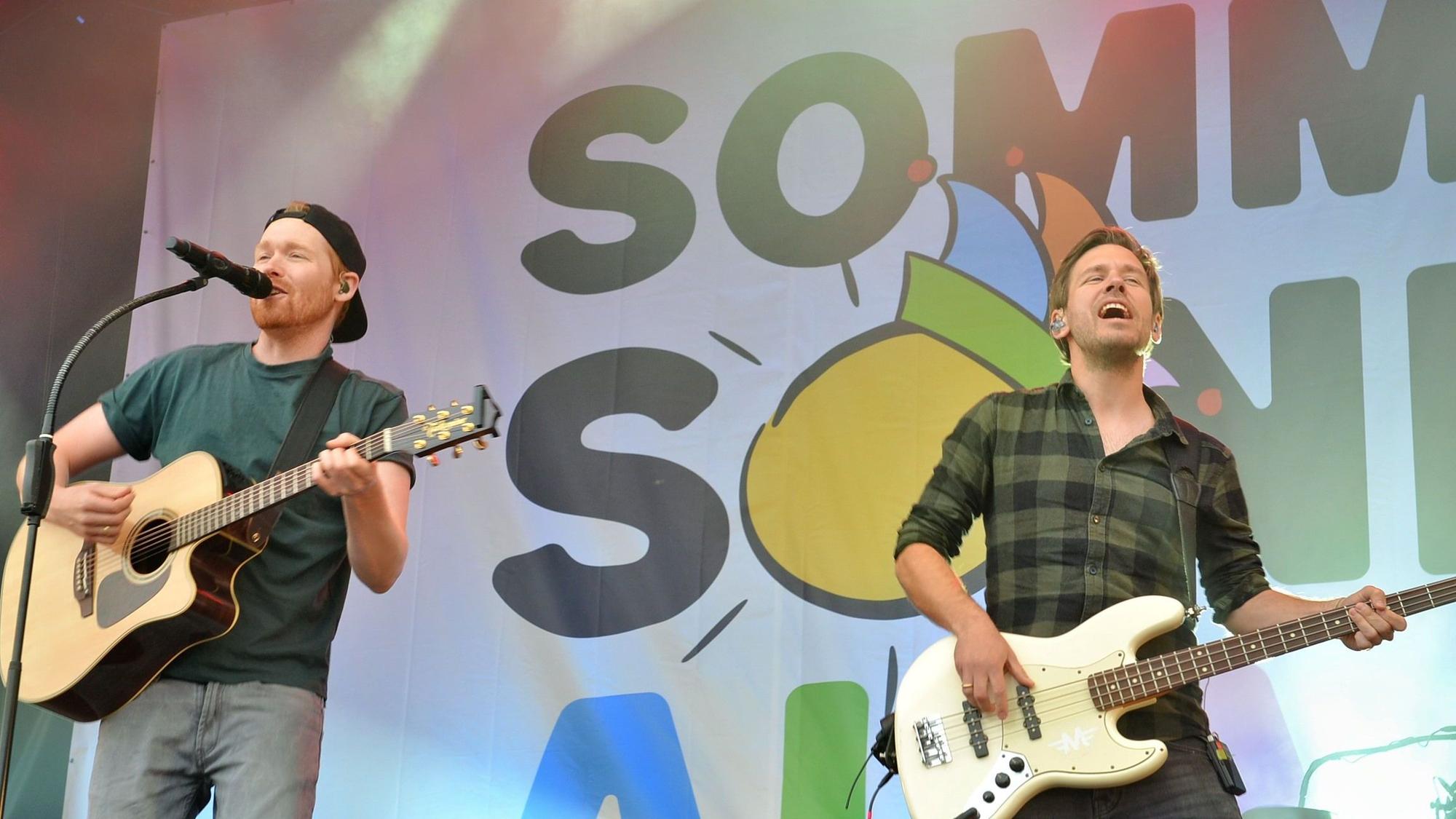 Zwei Musiker der Band der Gruppe „Miljö“ stehen auf der Bühne.