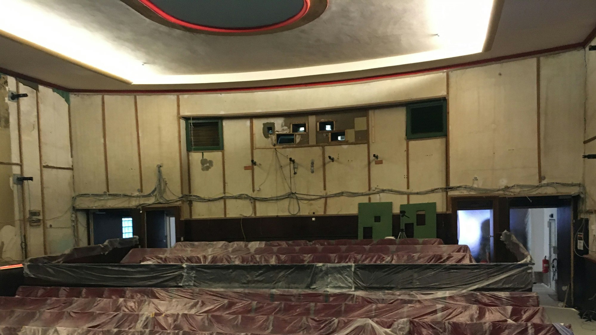 Der ausgeräumte Kinosaal mit nackten Wänden und den mit durchsichtiger Folie abgedeckten Sitzreihen.