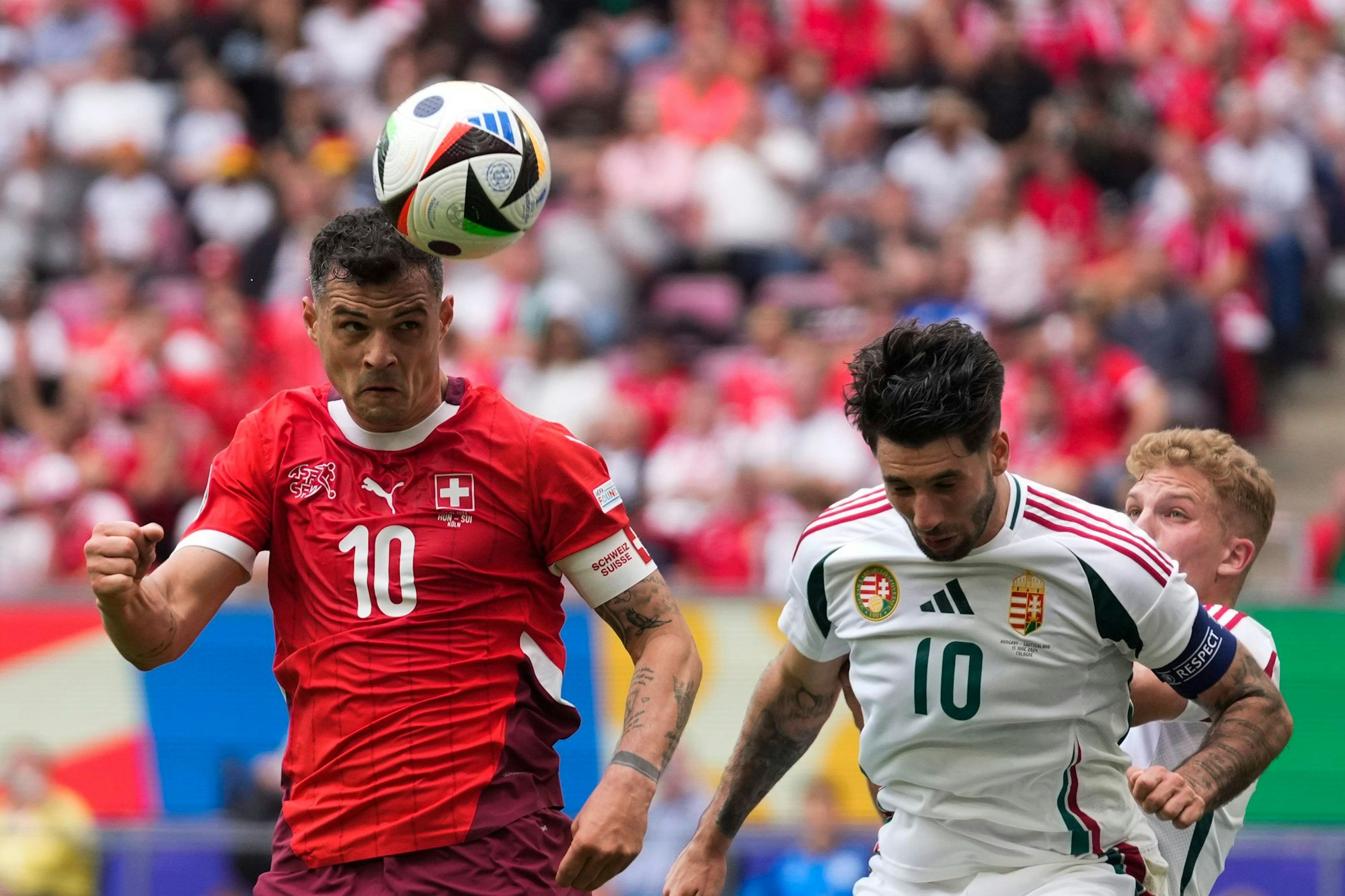 Der Schweizer Granit Xhaka (l.) ist vor Ungarns Dominik Szoboszlai mit dem Kopf am Ball.