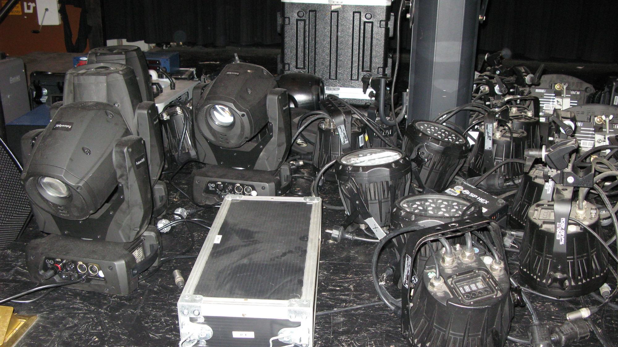 Auf der Bühne des Kur-Theaters stehen zahlreiche abmontierte Scheinwerfer und Koffer mit technischem Equipment.