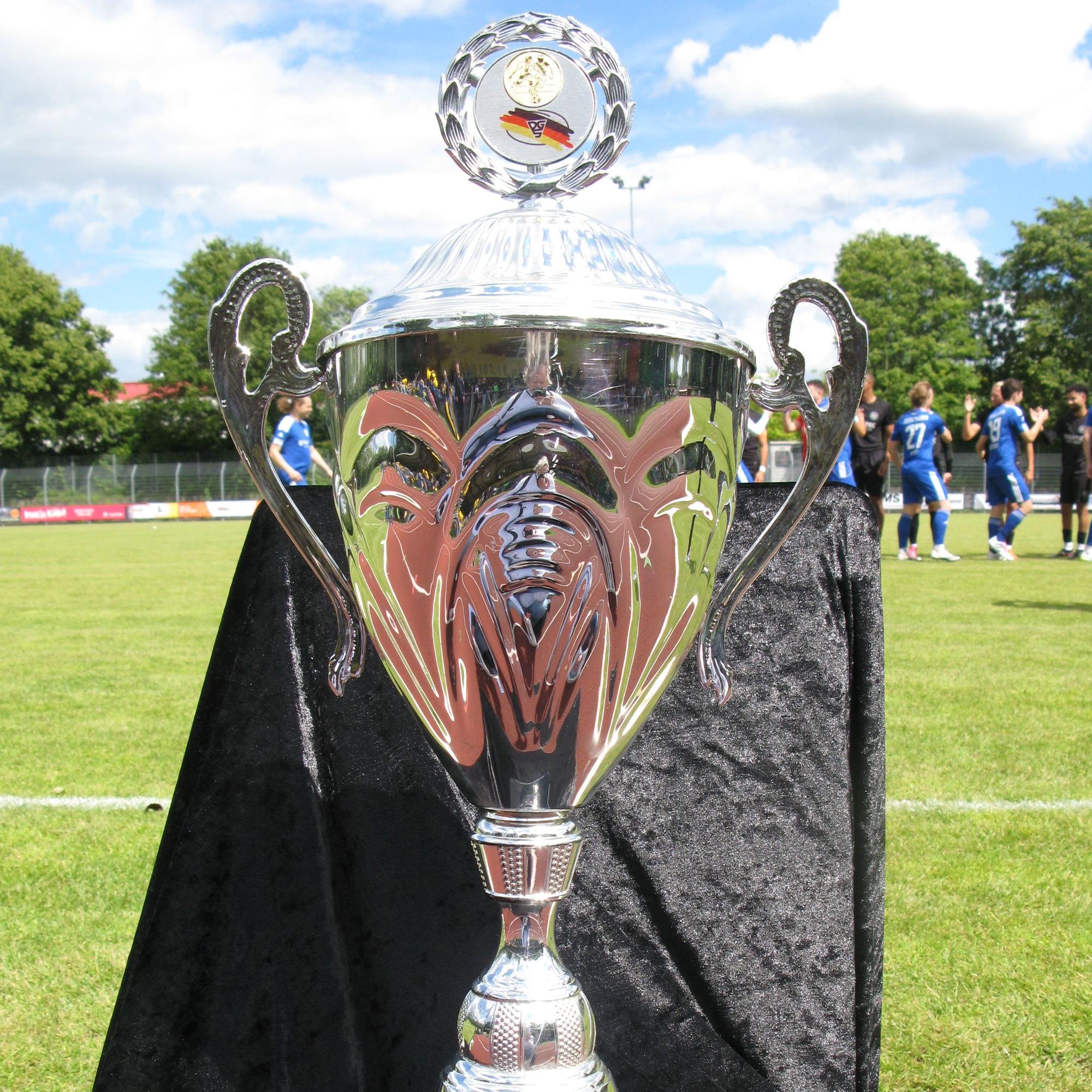 Der große, silberne Pokal für den Deutschen Meister im Gehörlosen-Fußball am Spielfeldrand.