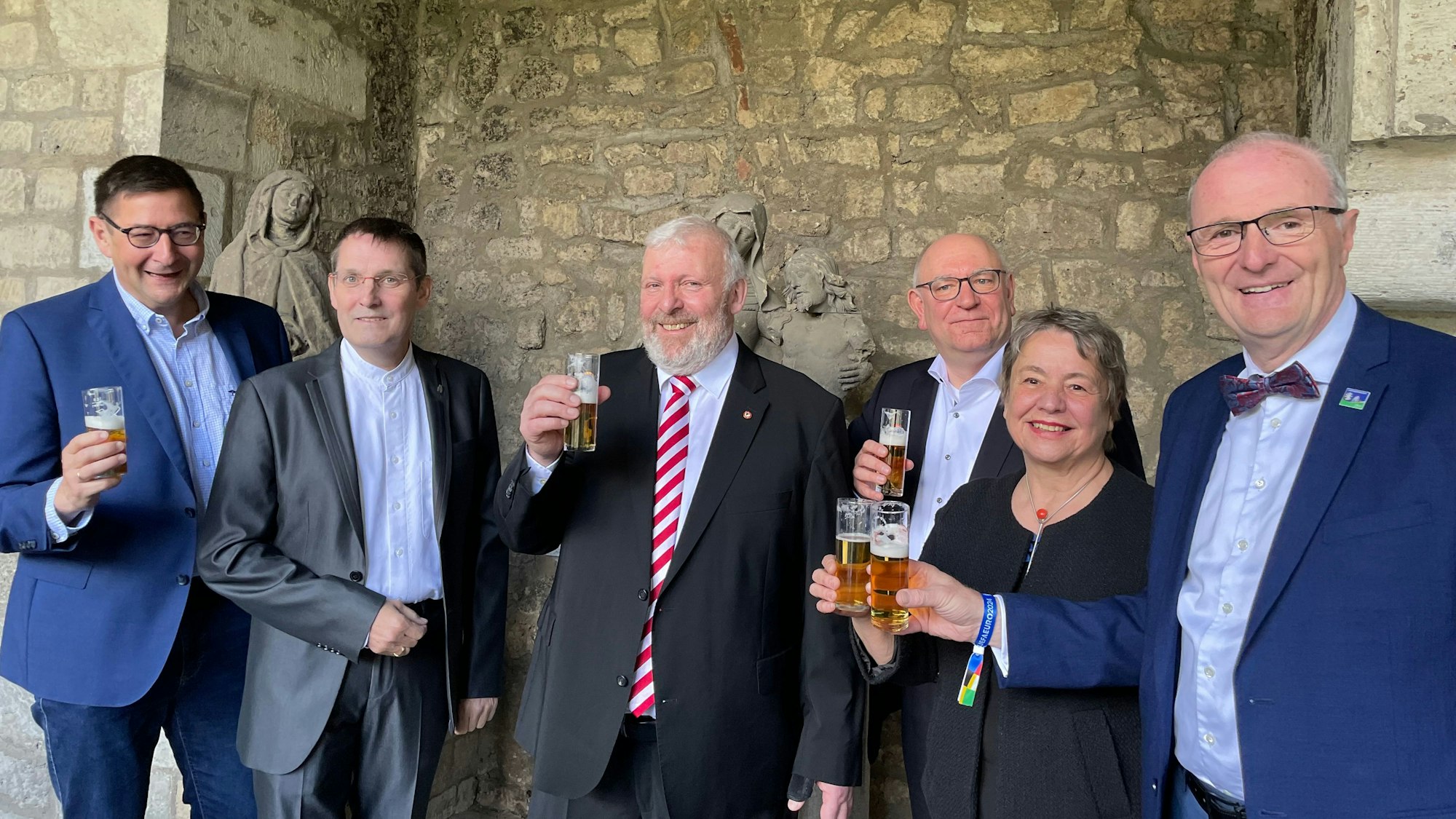 Fünf Männer und eine Frau prosten sich mit Kölscgläsern zu.