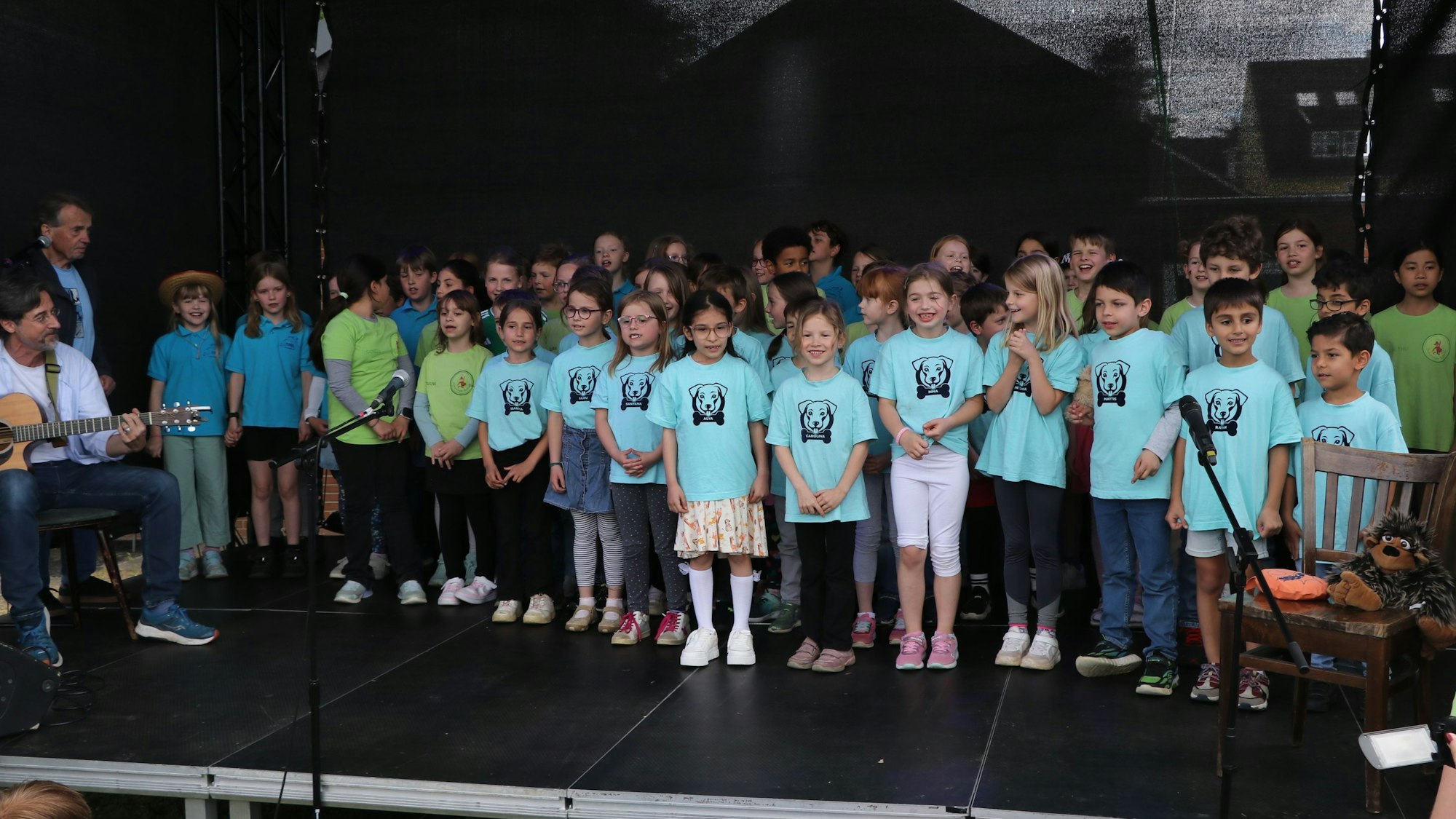 Auf dem Bild sind Kinder auf der Bühne zu sehen.