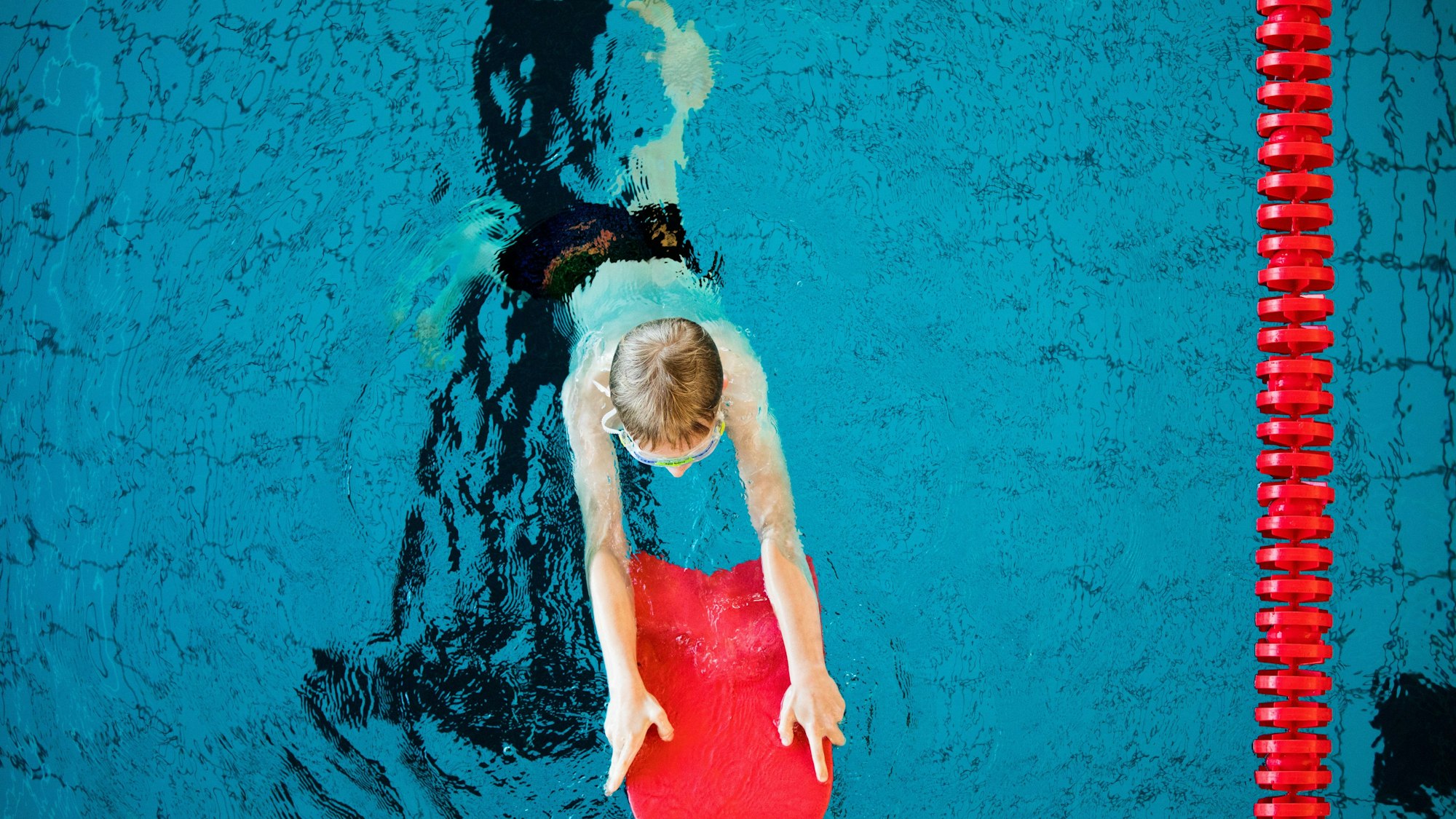 Ein Junge nimmt an einem Schwimmkurs für Kinder der DLRG teil.