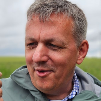 Ein Mann hält eine kleine Kröte in der Hand.