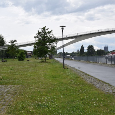 Die Katzenbuckelbrücke verbindet das Mülheimer Ufer mit der nordöstlichen Spitze des Jugendparks auf der ‚Katzenkopf‘ genannten Mülheimer Rheinhalbinsel.