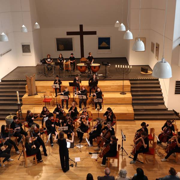 Ein Orchester musiziert in einer Kirche.