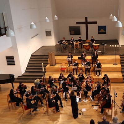 Ein Orchester musiziert in einer Kirche.