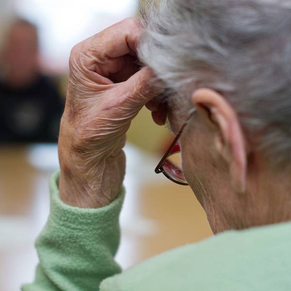 Eine demenzkranke Frau sitzt in einem Pflegeheim. Nachlassende kognitive Fähigkeiten führen bei viele Senioren zu Frustrationen.