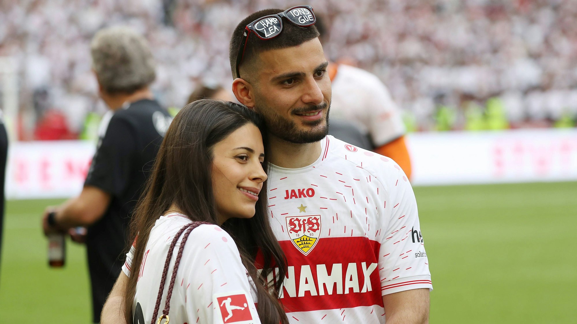 Deniz Undav und seine Frau Tanja posieren auf dem Spielfeld.