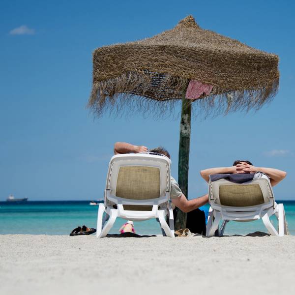 Urlauber liegen am Strand an der Plaja de Muro im Norden der Mittelmeerinsel Mallorca.