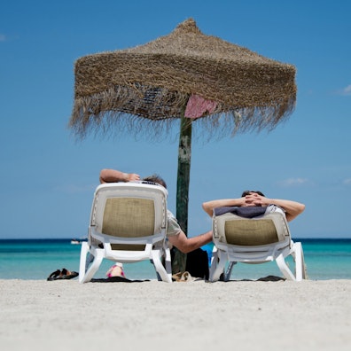 Urlauber liegen am Strand an der Plaja de Muro im Norden der Mittelmeerinsel Mallorca.