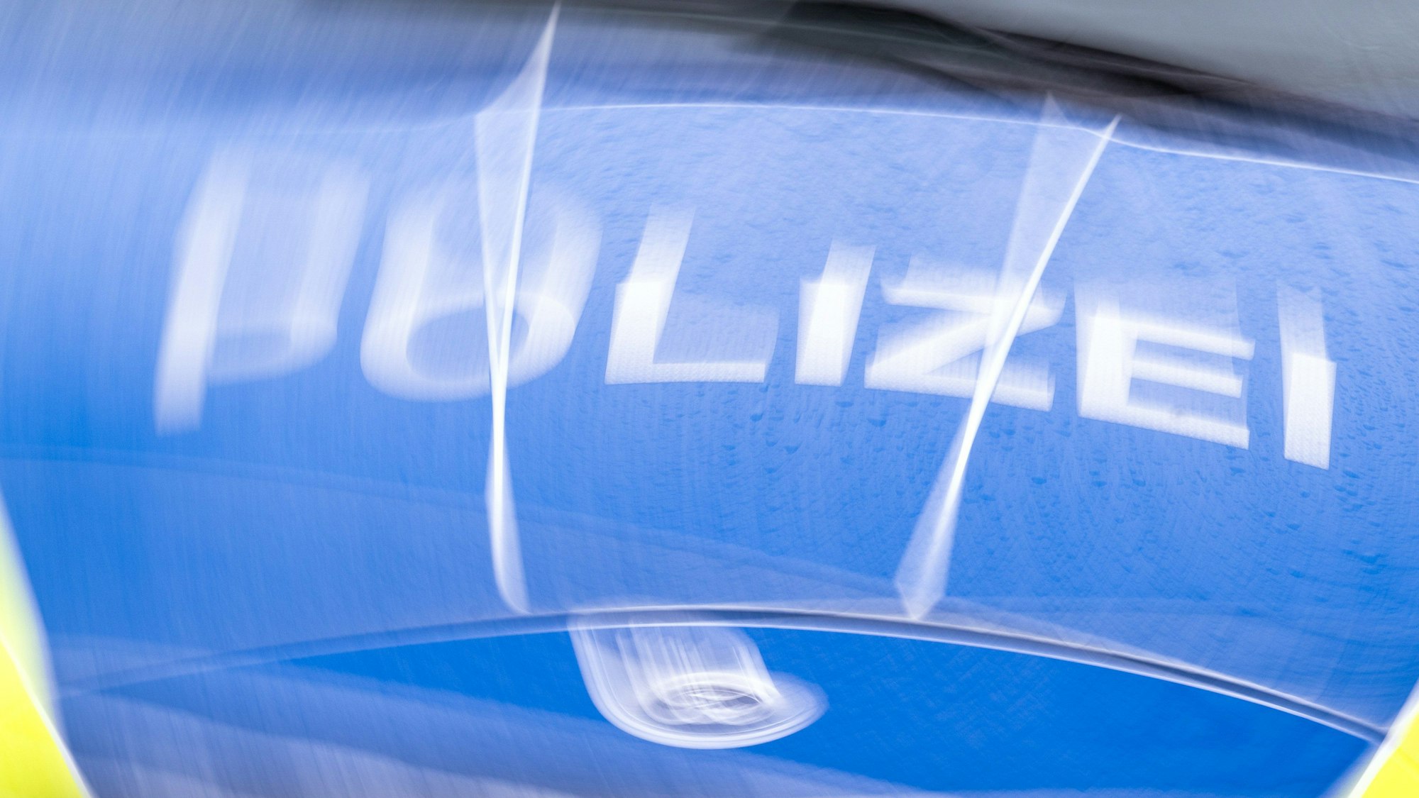 Der Schriftzug „Polizei“ auf der Kühlerhaube eines Autos.