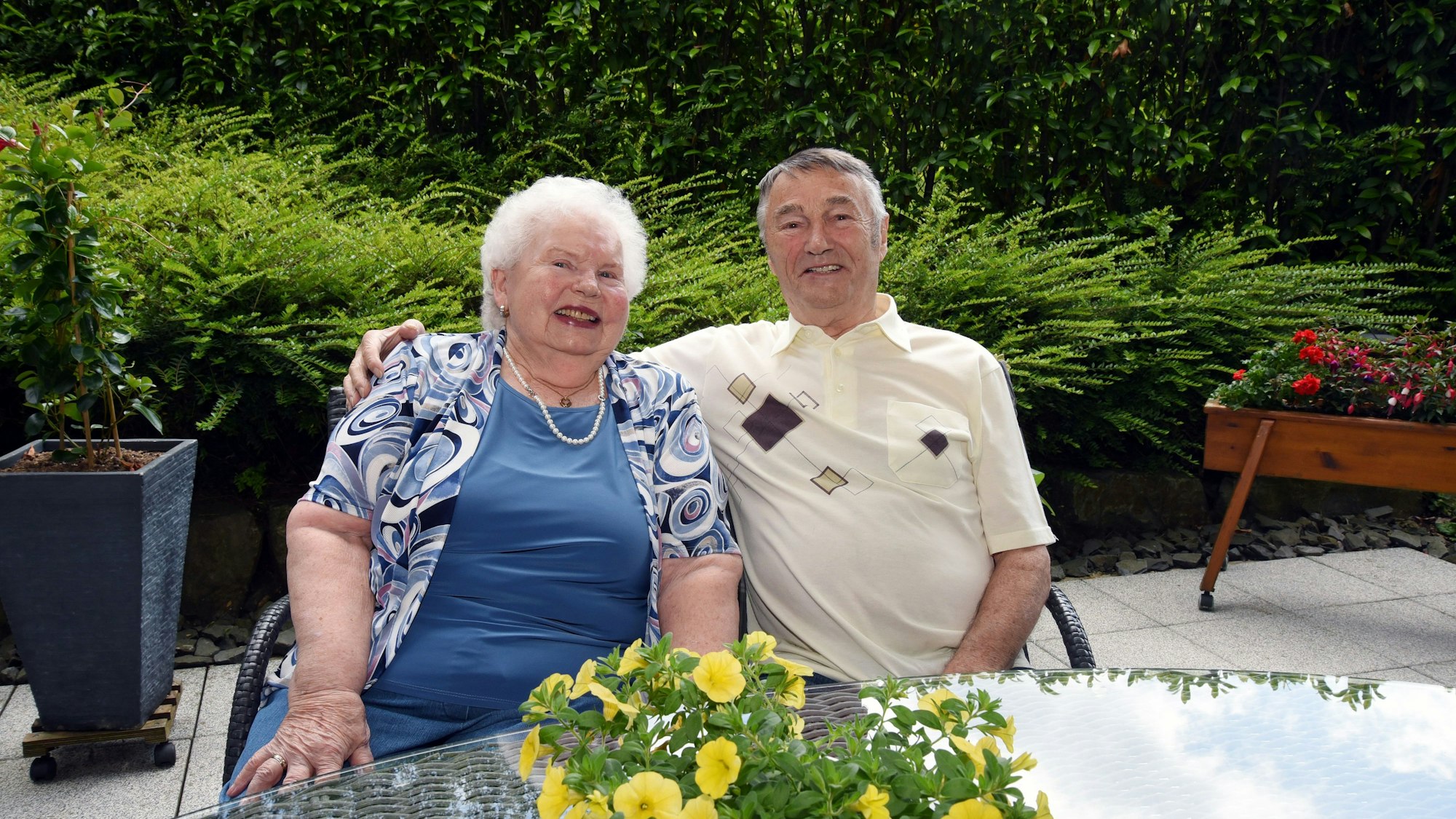 Hildegard und Horst Seemann sitzen gemeinsam an einem Tisch auf ihrer Terrasse.
