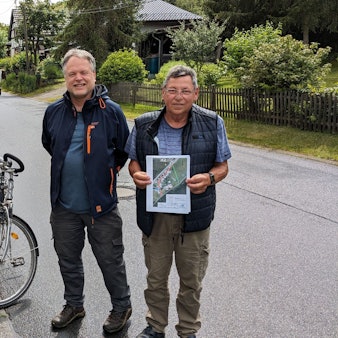 Bürgerinnen und Bürger aus Alt-Katzvey stehen an der Straße „Am Katzenstein“.